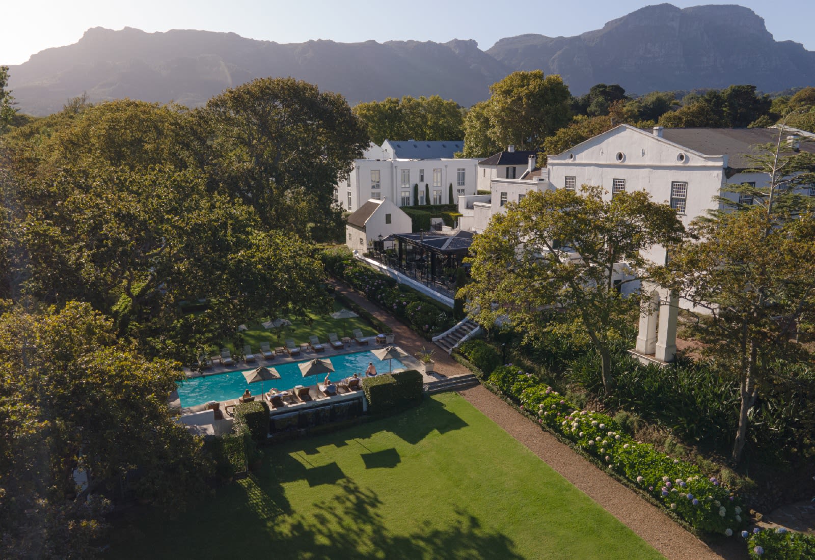Aerial of the estate, pool and gardens with Table Mountain range behind