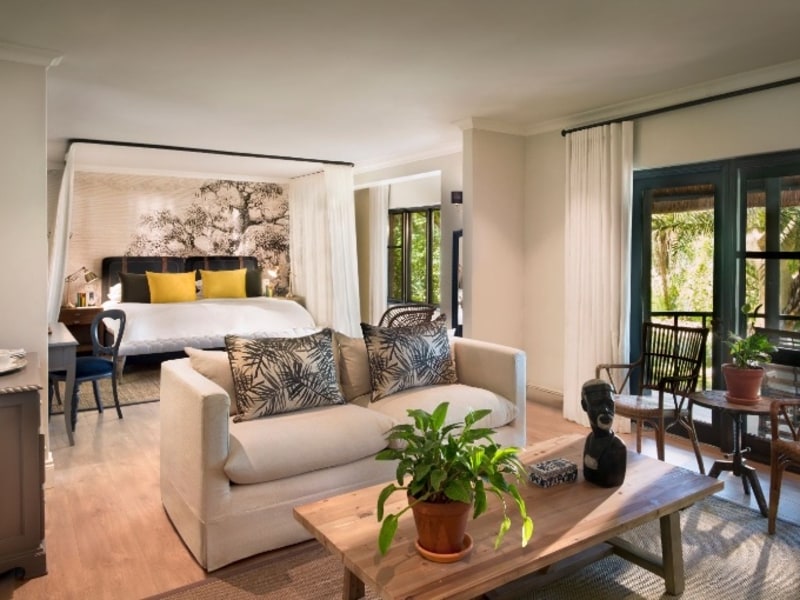 Garden View Suite with a sitting area, canopy bed and doors opening onto the veranda