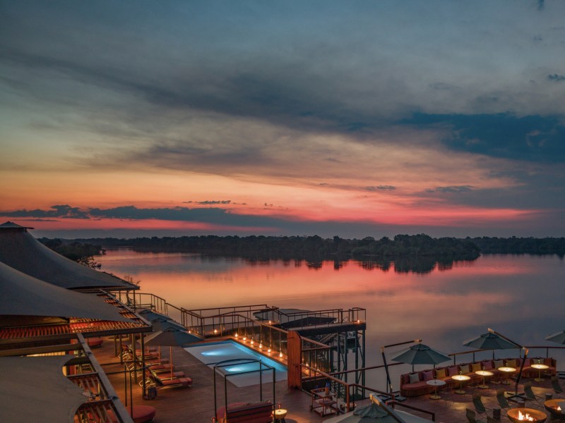 Main pool deck over the river at sunset, Anantara Tented Camp Kafue River