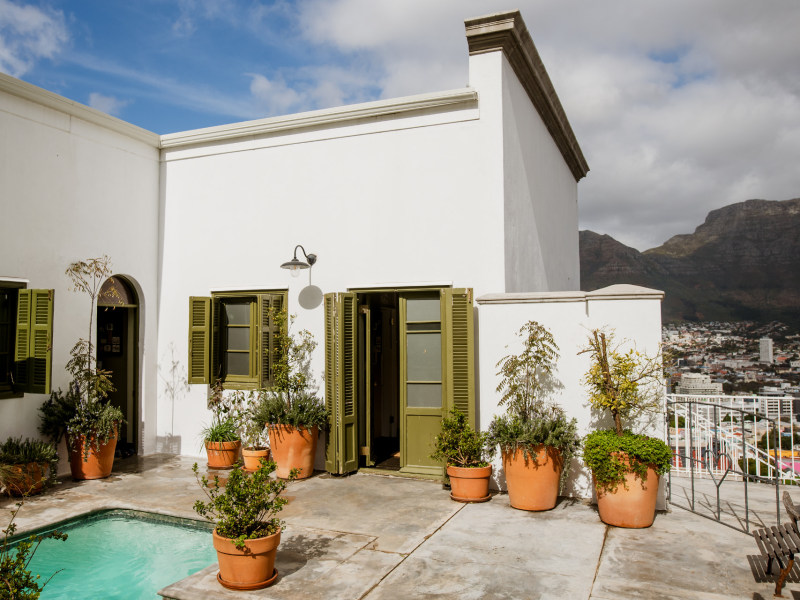 Courtyard plunge pool with potted plants, Table Mountain behind