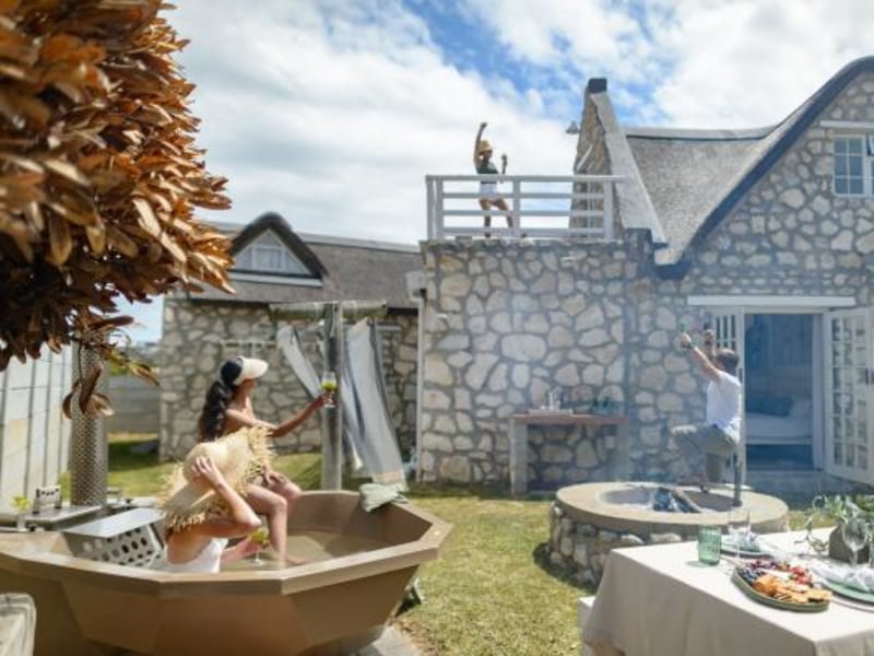 Kob Cottage, a stone and thatch home with wood-fired hot tubs in Struisbaai