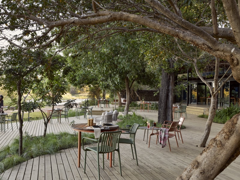 Dining deck shaded by riverine trees, Lion Sands River Lodge