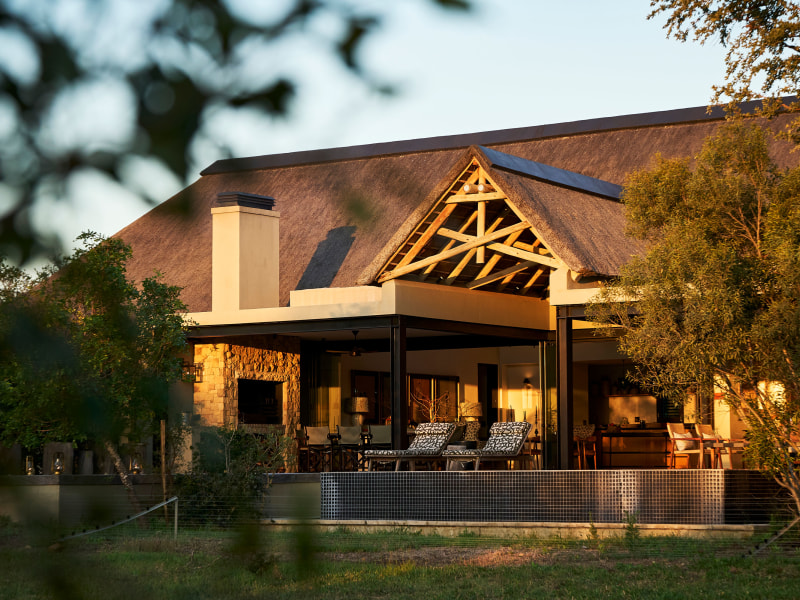 Thatched villa and covered terrace in late light, Monwana Villa