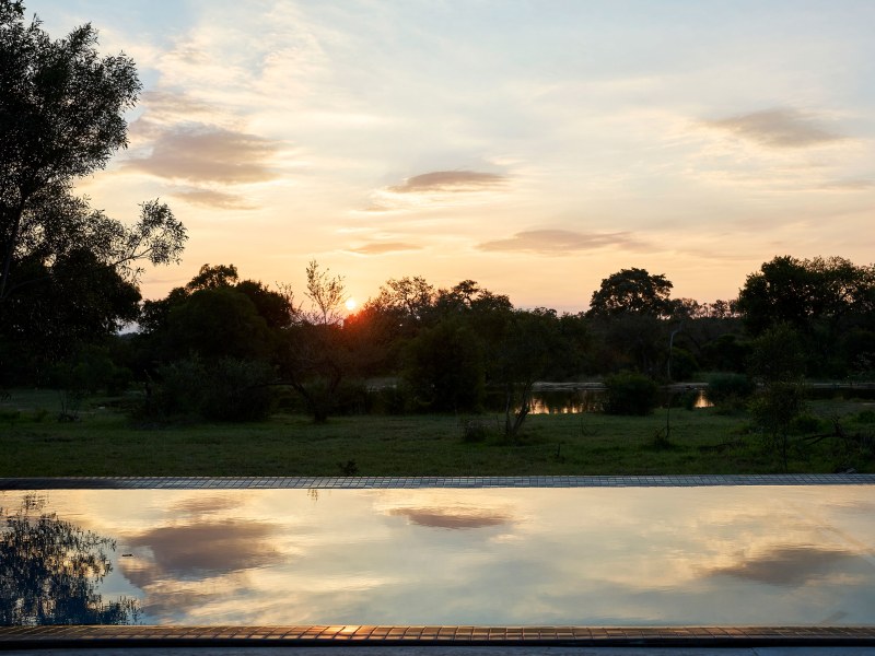 Sunset over the waterhole from the pool, Monwana Villa