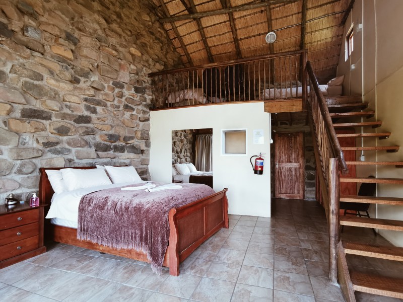 Stone-walled bedroom with loft at Ntsikeni Lodge