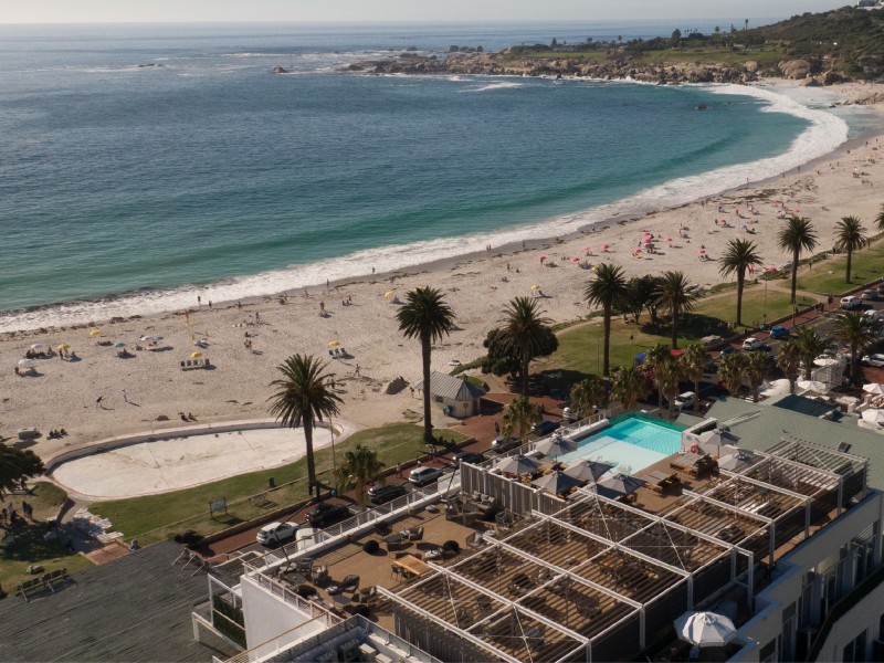 Aerial view of Camps Bay beach with the hotel's rooftop