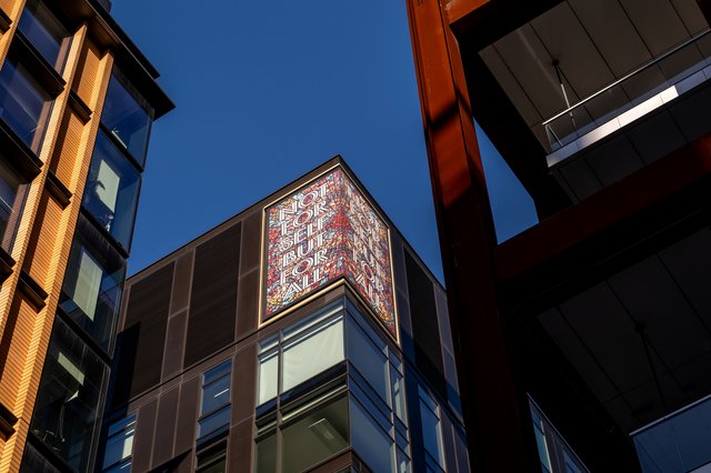 The statement on top of Camden Council&#x27;s 5 Pancras Square office is shown in this image. The statement reads not for self but for all in colourful tiles.