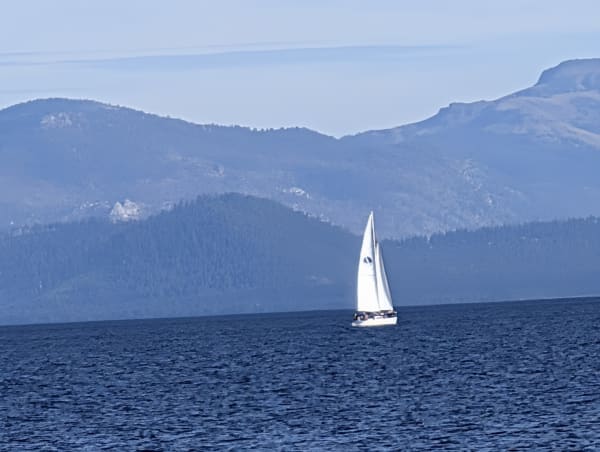 Sailboat on lake tahoe with blue gradiant mountain background