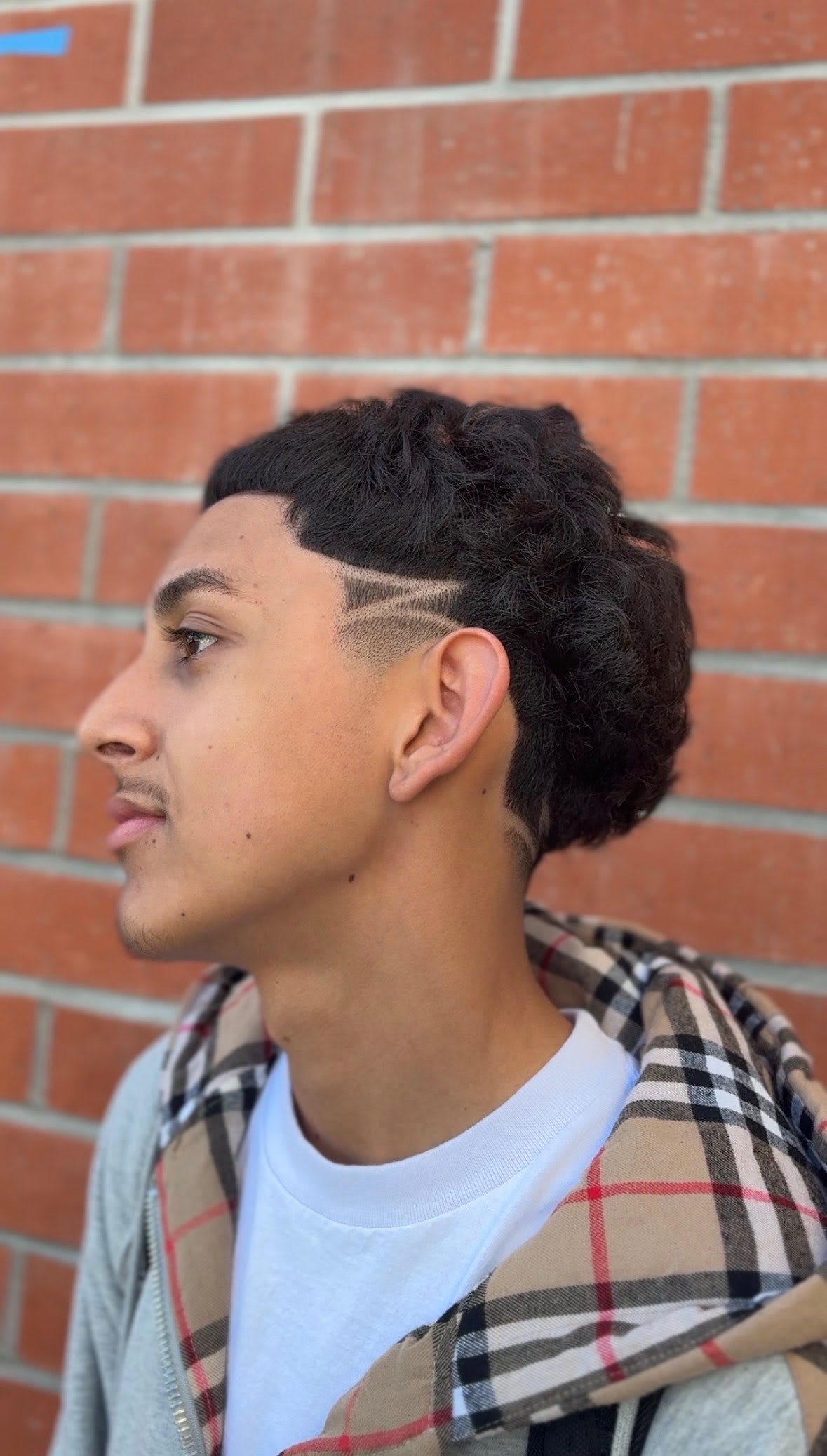 Side profile of a taper fade with a design