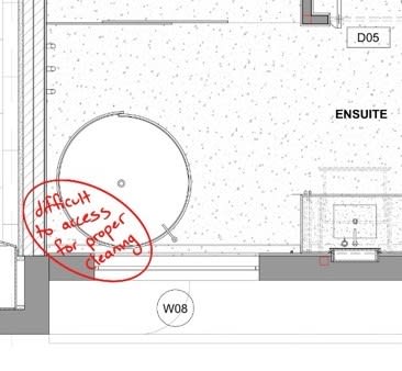 Freestanding bathtub pushed directly against the wall making it impossible to clean behind
