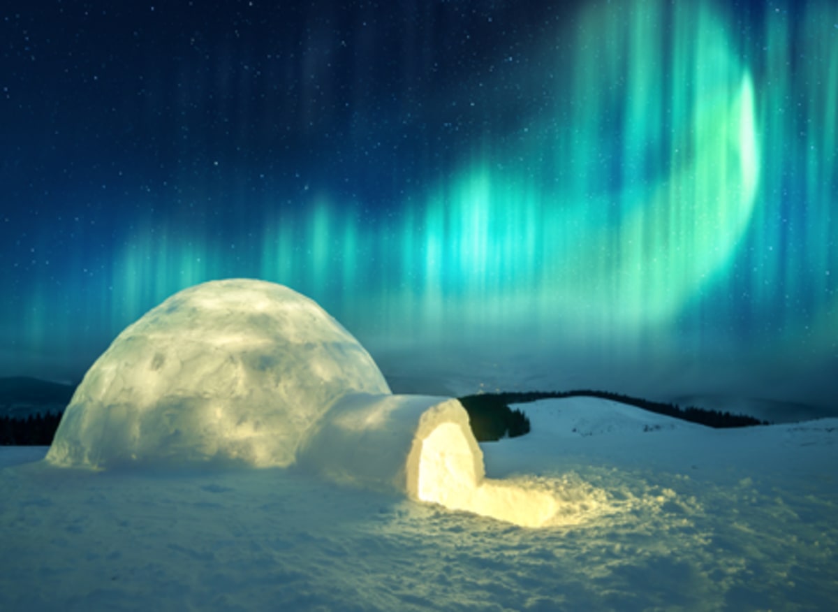 Glowing igloo under dramatic teal and blue aurora curtains