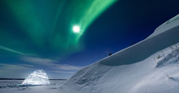 Aurora and snow variant landscape with igloo silhouette