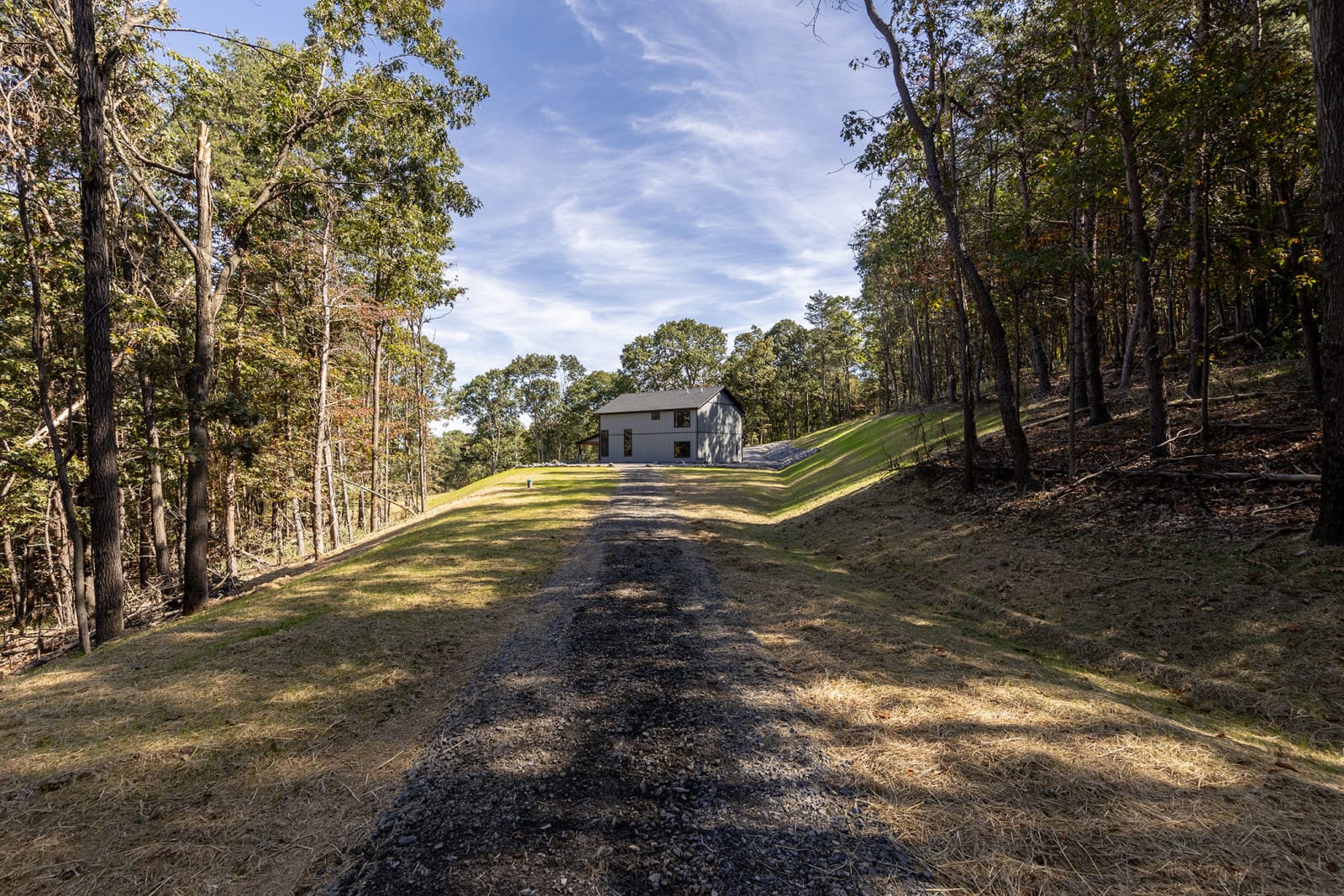 Long gravel driveway through trees leading up to the Bluffs Ridge home on the hilltop
