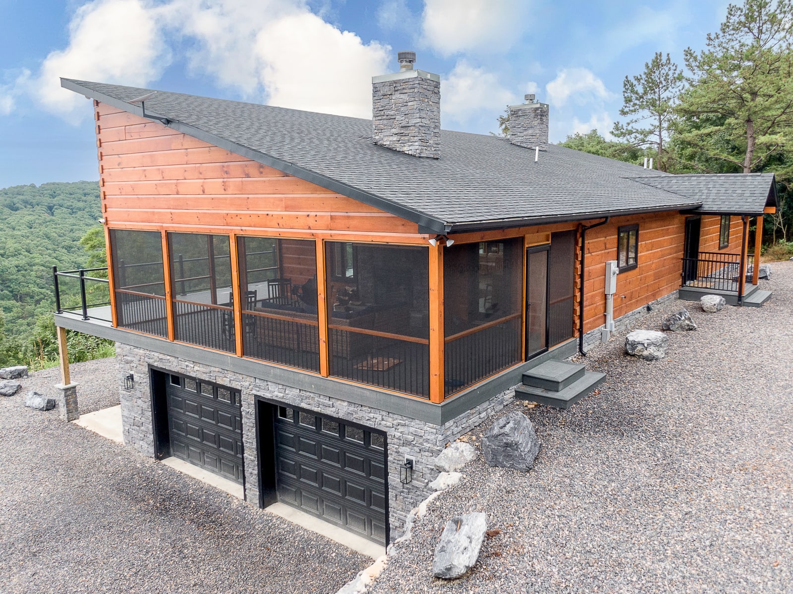 Front corner view of the Waite home showing cedar siding, stone base, and wall of windows