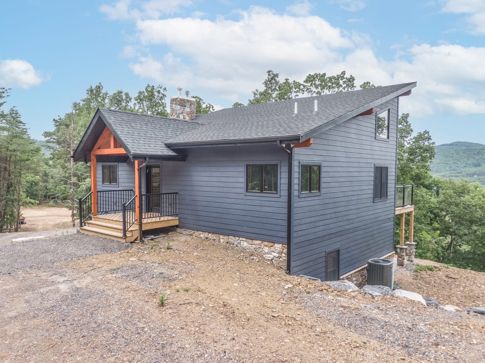 Front facade of the Britton home showing gray siding and timber porch entry