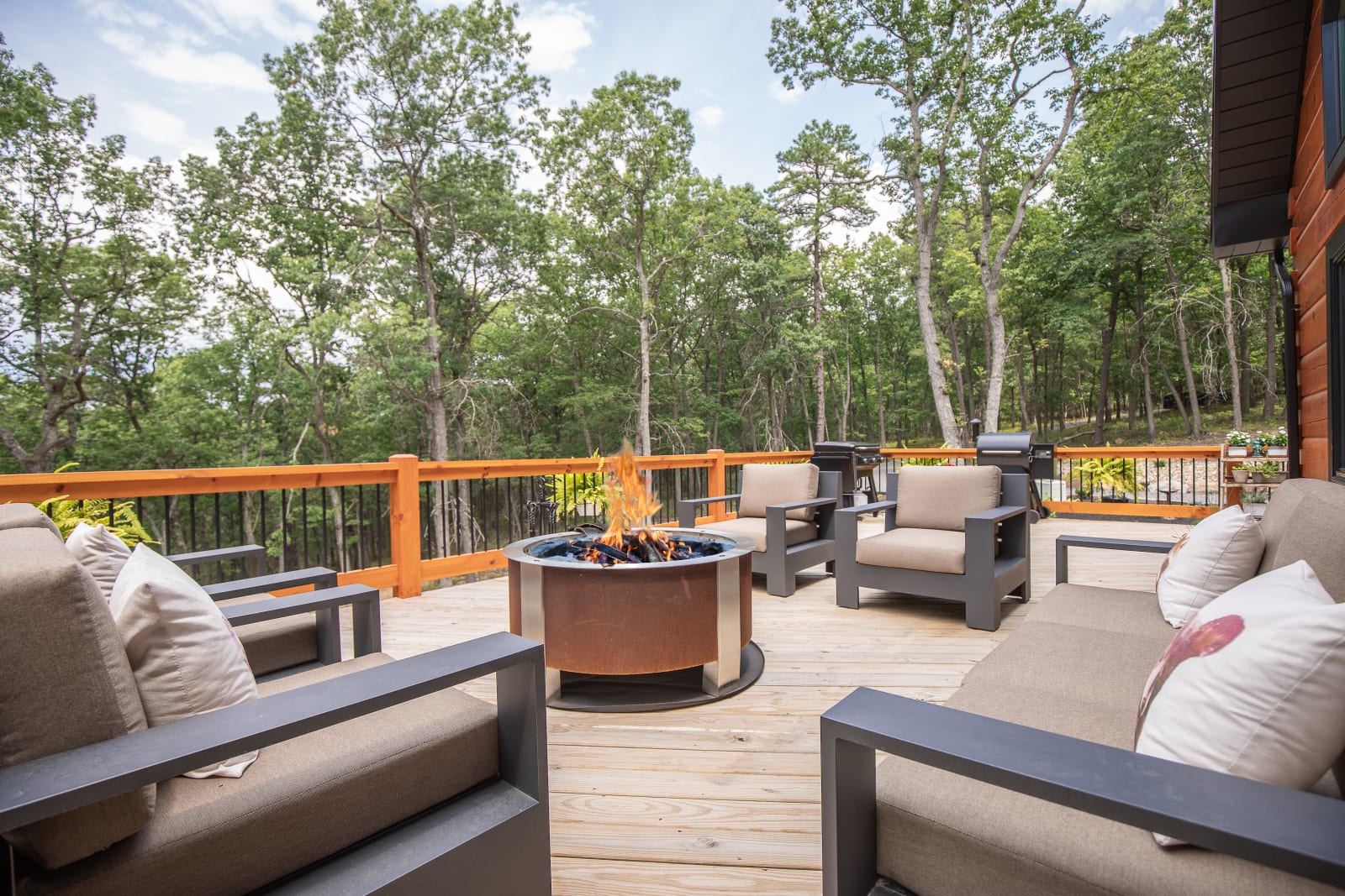 Wraparound deck at twilight with firelight glowing through the great room windows
