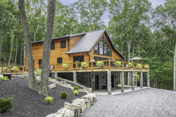 The Hendrie — full log home with wraparound deck and metal roof in the WV hills