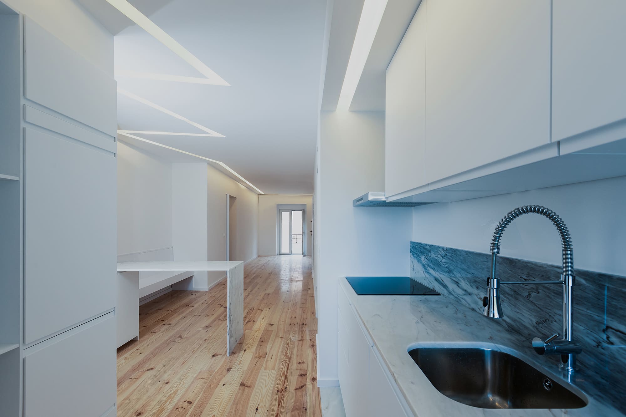 2-Apartamento-Lisboa-Lisboa - Situado numa das principais avenidas habitacionais de Lisboa, o Projeto “Apartamento na Avenida de Roma” pelo Atelier Bruno Câmara Arquitectos, nasce da remodelação de um antigo consultório médico que, face às necessidades atuais de habitação e com o regresso da população activa ao centro da cidade, reassume a sua Identidade de Projeto original.
Bruno Câmara, defende que “Arquitetura é luz, a nobreza está nos materiais”. A habitação apresenta-se como uma materialização dos ideais do Atelier. Com divisões seguindo linhas minimalistas da Arquitetura Moderna. O conceito do projeto é definido pela formalização de um elemento contínuo de luz, que unifica o espaço entre as duas fachadas. Um rasgo luminoso que percorrendo o teto, ilumina a cozinha, encaminhando-nos até à sala de estar. 
O uso e escolha dos materiais é a prioridade da CVZ. A madeira nos pavimentos serve como elemento de união, entre diferentes espaços que se destacam pela simplicidade de linhas. A pedra torna-se elemento central, a sua presença é sentida na caracterização do espaço, nas áreas de maior intimidade onde a composição da sua materialidade traz às áreas a grandiosidade do material.
A cidade de Lisboa está a renascer em pleno século XXI. Parte da premissa e ideais do Estado novo, nos anos 30, era oferecer habitação para todos os cidadãos. Na nossa atualidade, face às necessidades modernas, denota-se o regresso da população ao centro da cidade, nesse sentido, a remodelação deste apartamento simboliza o retorno a uma das avenidas de maior charme de Lisboa, a Avenida de Roma.