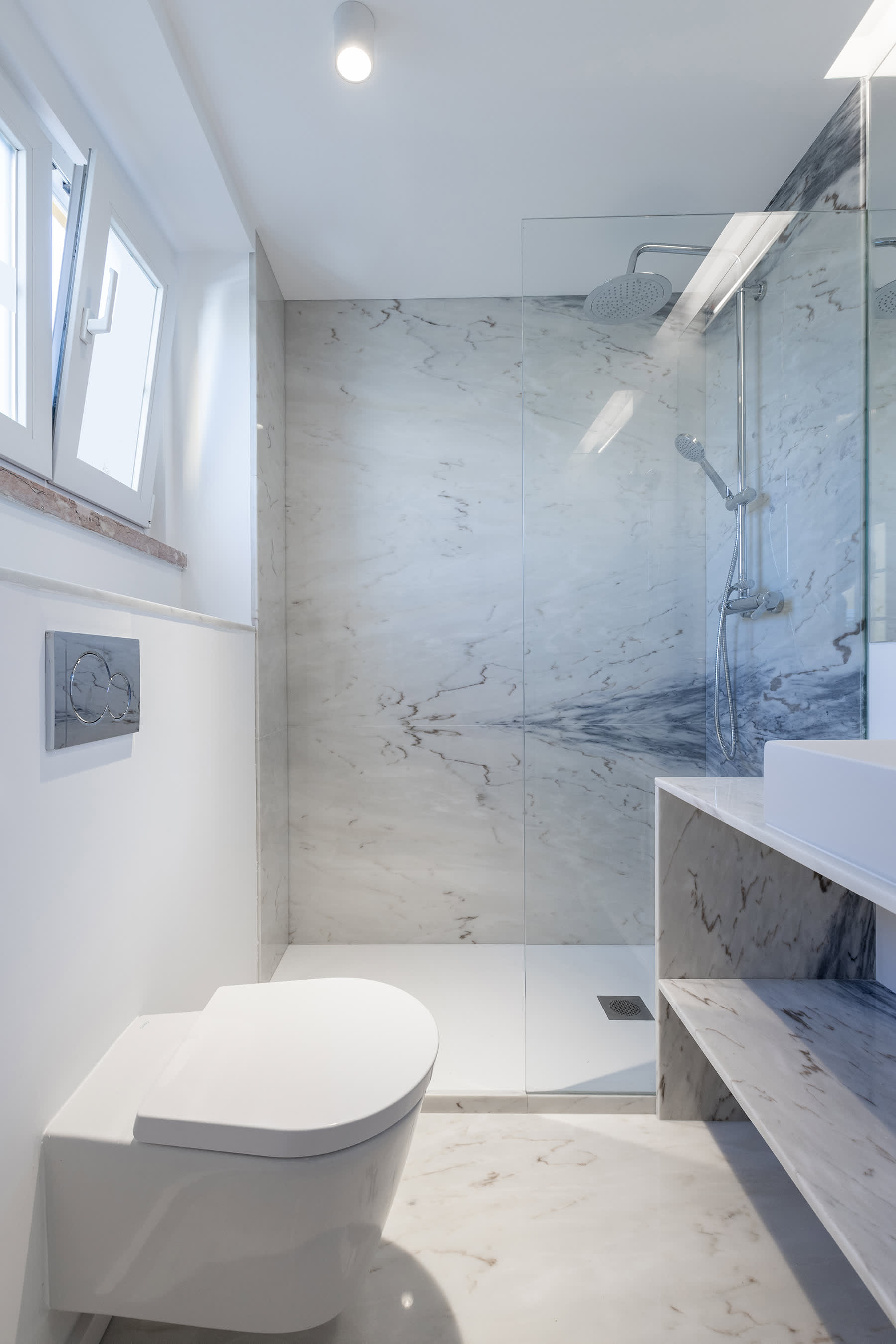 4-Apartamento-Lisboa-Lisboa - Situado numa das principais avenidas habitacionais de Lisboa, o Projeto “Apartamento na Avenida de Roma” pelo Atelier Bruno Câmara Arquitectos, nasce da remodelação de um antigo consultório médico que, face às necessidades atuais de habitação e com o regresso da população activa ao centro da cidade, reassume a sua Identidade de Projeto original.
Bruno Câmara, defende que “Arquitetura é luz, a nobreza está nos materiais”. A habitação apresenta-se como uma materialização dos ideais do Atelier. Com divisões seguindo linhas minimalistas da Arquitetura Moderna. O conceito do projeto é definido pela formalização de um elemento contínuo de luz, que unifica o espaço entre as duas fachadas. Um rasgo luminoso que percorrendo o teto, ilumina a cozinha, encaminhando-nos até à sala de estar. 
O uso e escolha dos materiais é a prioridade da CVZ. A madeira nos pavimentos serve como elemento de união, entre diferentes espaços que se destacam pela simplicidade de linhas. A pedra torna-se elemento central, a sua presença é sentida na caracterização do espaço, nas áreas de maior intimidade onde a composição da sua materialidade traz às áreas a grandiosidade do material.
A cidade de Lisboa está a renascer em pleno século XXI. Parte da premissa e ideais do Estado novo, nos anos 30, era oferecer habitação para todos os cidadãos. Na nossa atualidade, face às necessidades modernas, denota-se o regresso da população ao centro da cidade, nesse sentido, a remodelação deste apartamento simboliza o retorno a uma das avenidas de maior charme de Lisboa, a Avenida de Roma.