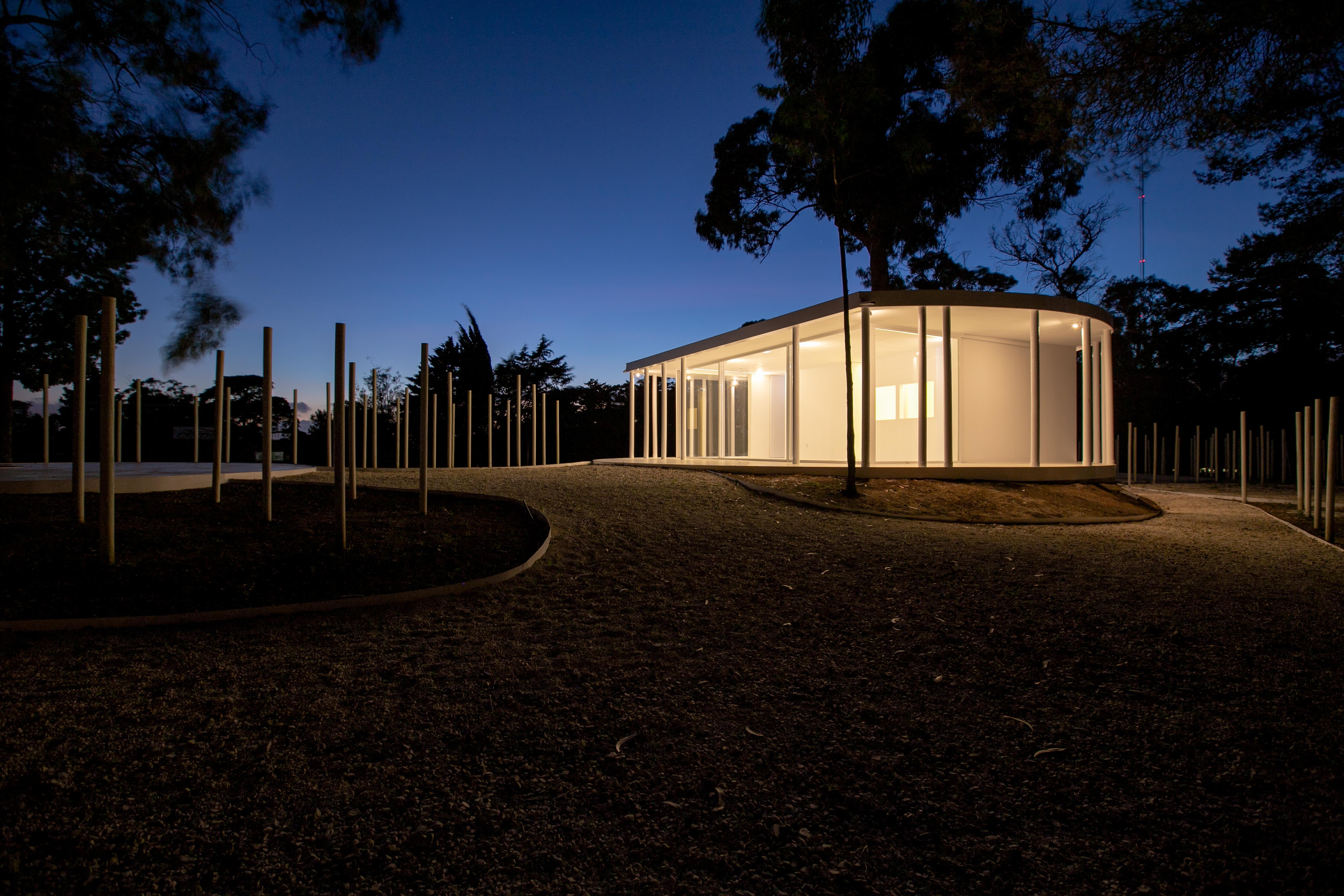 10-Vila-Lisboa-Lisboa - Aclamado por todos como o pulmão verde de Lisboa, Monsanto tem estado, de certa forma, abandonado à deterioração natural, carecendo de estruturas funcionais e apelativas de apoio aos habitantes da cidade de Lisboa. A par das novas tendências do estilo de vida dos portugueses, nomeadamente dos residentes nas grandes cidades, verifica-se uma procura crescente de espaços verdes, quer para a prática de desportos, quer para atividades de lazer ou apenas para usufruto e maior contacto com a natureza. Monsanto não é exceção, não obstante a falta de condições do parque florestal.
Monsanto tem uma nova “Floresta Branca”. Correspondendo às expectativas de muitos lisboetas, após um longo período de espera, vários projetos de requalificação estão a ser desenvolvidos pela Câmara Municipal de Lisboa e Juntas de Freguesia em diferentes zonas de Monsanto. A Junta de Freguesia de Benfica abriu um concurso público de reabilitação, o contrato entregue à Empresa CVZ Construções, que, em parceria com o gabinete de Arquitetura Bruno Câmara Arquitetos, desenvolveu todo o projeto de Concepção e Construção de um novo restaurante/bar com zonas exteriores, incluindo vários percursos pedonais e espaços lúdicos. Bruno Câmara Arquitectos adotou o conceito de “Uma Floresta Branca”, para criar um Projeto globalmente marcado pela cor branca, seguindo linhas minimalistas de Arquitetura Moderna e Contemporânea. Segundo o Arquiteto Bruno Câmara, Autor do Projeto,  o conceito “materializa todos os elementos propostos, integrando os mesmos no enquadramento paisagístico de Monsanto. 3.411 troncos de madeira pintados a branco formam vários espaços exteriores com diferentes funções, desde pequenos auditórios a espaços de lazer, envolvendo o espaço principal de restaurante/bar com a zona interior e exterior, que valoriza a espacialidade e ligação à natureza envolvente.”
A nova construção destaca-se assim pelo seu branco minimalista inserido no verde de Monsanto, que cria harmonia com os espaços envolventes, quer pelas suas linhas curvas, quer pelos materiais utilizados, conferindo-lhes modernidade.