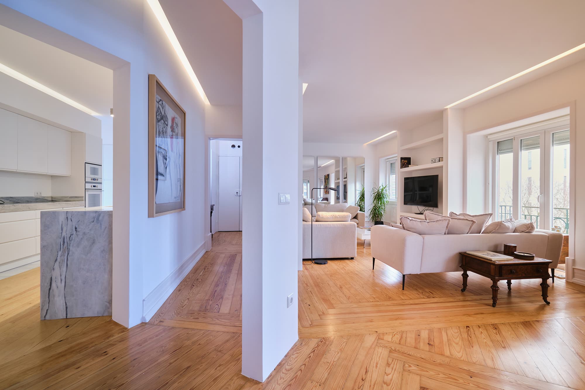 3-Apartamento-Lisboa-Lisboa - O apartamento insere-se num edifício de gaveto entre a Avenida de Berna e Avenida Marquês de Tomar no bairro das Avenidas Novas, localizado na zona central de Lisboa, junto à Avenida da República, uma das principais vias da cidade. A Avenida de Berna tem uma longa história de Glamour e estilo de vida de classe alta e essa cultura esteve presente na nossa forma de abordar o Projeto.
O bairro é definido por vias largas de dois sentidos, logradouros ajardinados e coerência estética no desenho das fachadas, tornando Avenida de Berna numa das zonas mais valorizadas de Lisboa. O edifício  é composto por um piso térreo e quatro pisos seguintes. A construção é definida por fundações em alvenaria de pedra, que é o mesmo material presente nas paredes exteriores. Os interiores por si, encontram-se em tijolo maciço, com uma laje mista e cobertura em telha marselha assente em barrotes de madeira. São criadas novas aberturas interiores, o layout da cozinha é alterado para permitir a continuidade e fluidez espacial entre o espaço social definido pelas divisões conectadas.
O alçado principal é definido por uma métrica de vãos com de guardas metálicas, assim como vãos exteriores em alumínio com vidro duplo e com uma cobertura de duas águas em cerâmica. Com a intervenção da CVZ Construções, nasce uma nova zona social. Uma nova disposição, com maior espacialidade e luminosidade, na cozinha, sala e Instalações Sanitárias. O novo espaço traz mobiliário fixo de biblioteca e zonas de iluminação indireta.