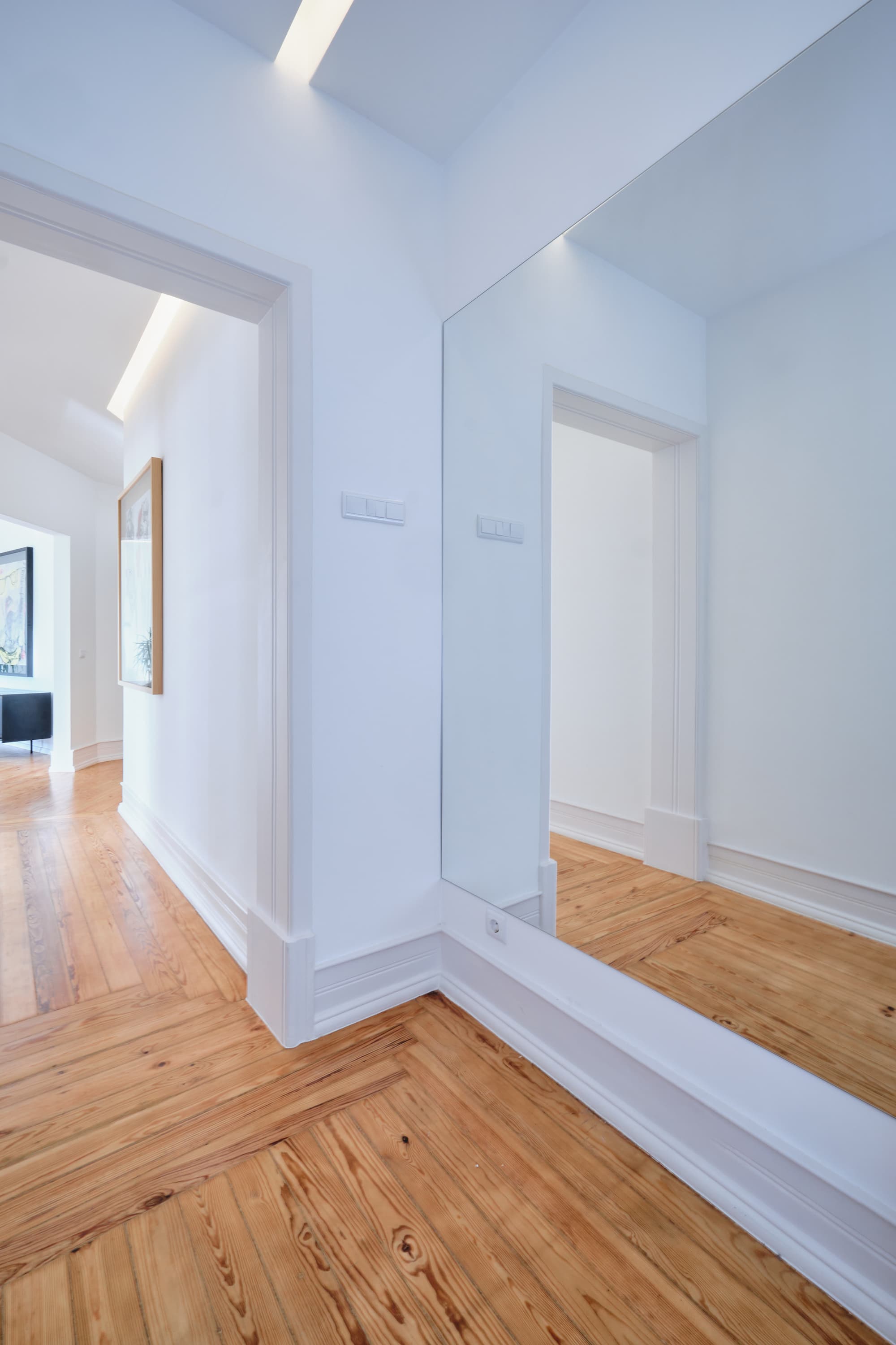 7-Apartamento-Lisboa-Lisboa - O apartamento insere-se num edifício de gaveto entre a Avenida de Berna e Avenida Marquês de Tomar no bairro das Avenidas Novas, localizado na zona central de Lisboa, junto à Avenida da República, uma das principais vias da cidade. A Avenida de Berna tem uma longa história de Glamour e estilo de vida de classe alta e essa cultura esteve presente na nossa forma de abordar o Projeto.
O bairro é definido por vias largas de dois sentidos, logradouros ajardinados e coerência estética no desenho das fachadas, tornando Avenida de Berna numa das zonas mais valorizadas de Lisboa. O edifício  é composto por um piso térreo e quatro pisos seguintes. A construção é definida por fundações em alvenaria de pedra, que é o mesmo material presente nas paredes exteriores. Os interiores por si, encontram-se em tijolo maciço, com uma laje mista e cobertura em telha marselha assente em barrotes de madeira. São criadas novas aberturas interiores, o layout da cozinha é alterado para permitir a continuidade e fluidez espacial entre o espaço social definido pelas divisões conectadas.
O alçado principal é definido por uma métrica de vãos com de guardas metálicas, assim como vãos exteriores em alumínio com vidro duplo e com uma cobertura de duas águas em cerâmica. Com a intervenção da CVZ Construções, nasce uma nova zona social. Uma nova disposição, com maior espacialidade e luminosidade, na cozinha, sala e Instalações Sanitárias. O novo espaço traz mobiliário fixo de biblioteca e zonas de iluminação indireta.