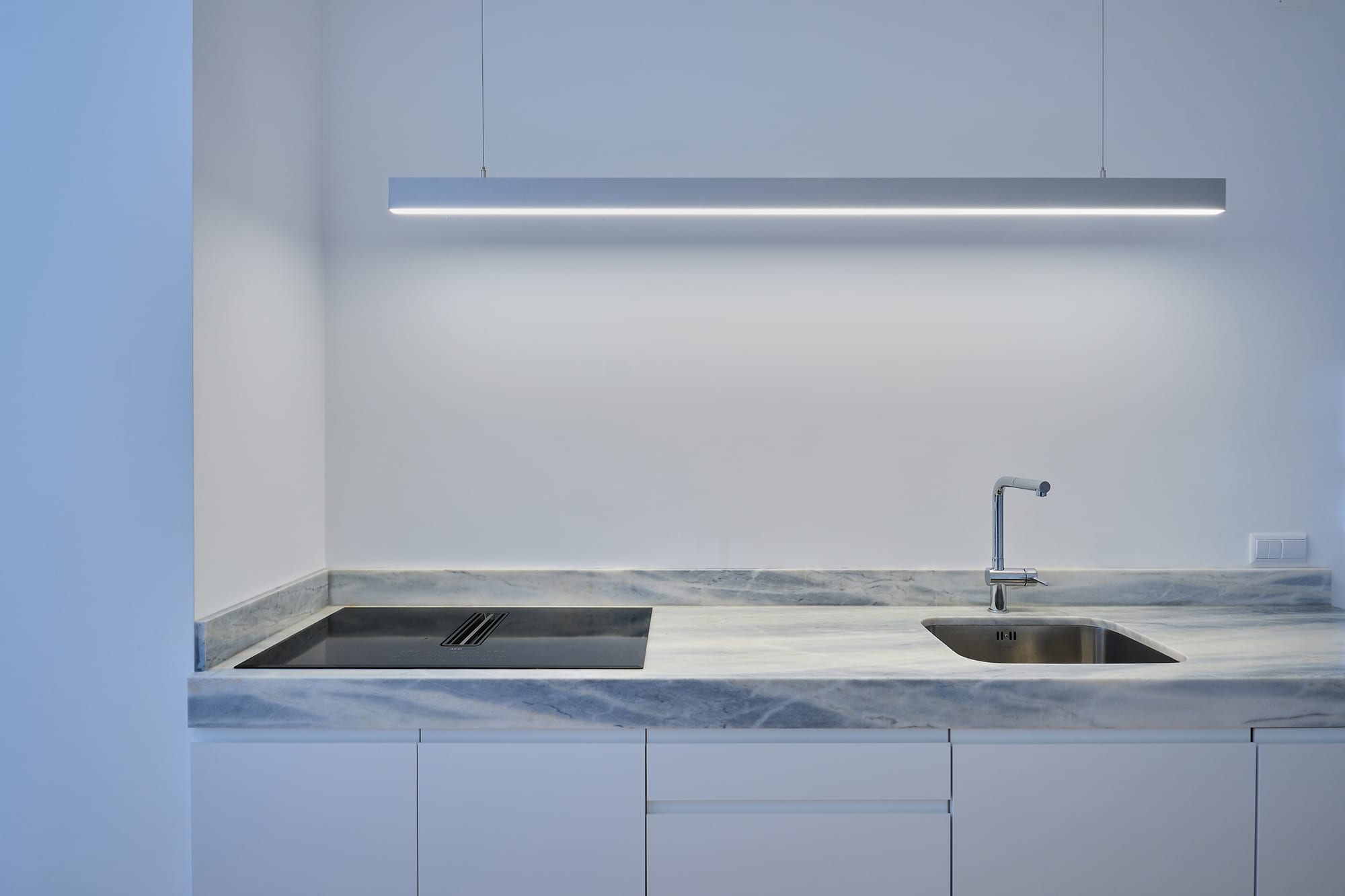 10-Apartamento-Lisboa-Lisboa - O apartamento insere-se num edifício de gaveto entre a Avenida de Berna e Avenida Marquês de Tomar no bairro das Avenidas Novas, localizado na zona central de Lisboa, junto à Avenida da República, uma das principais vias da cidade. A Avenida de Berna tem uma longa história de Glamour e estilo de vida de classe alta e essa cultura esteve presente na nossa forma de abordar o Projeto.
O bairro é definido por vias largas de dois sentidos, logradouros ajardinados e coerência estética no desenho das fachadas, tornando Avenida de Berna numa das zonas mais valorizadas de Lisboa. O edifício  é composto por um piso térreo e quatro pisos seguintes. A construção é definida por fundações em alvenaria de pedra, que é o mesmo material presente nas paredes exteriores. Os interiores por si, encontram-se em tijolo maciço, com uma laje mista e cobertura em telha marselha assente em barrotes de madeira. São criadas novas aberturas interiores, o layout da cozinha é alterado para permitir a continuidade e fluidez espacial entre o espaço social definido pelas divisões conectadas.
O alçado principal é definido por uma métrica de vãos com de guardas metálicas, assim como vãos exteriores em alumínio com vidro duplo e com uma cobertura de duas águas em cerâmica. Com a intervenção da CVZ Construções, nasce uma nova zona social. Uma nova disposição, com maior espacialidade e luminosidade, na cozinha, sala e Instalações Sanitárias. O novo espaço traz mobiliário fixo de biblioteca e zonas de iluminação indireta.