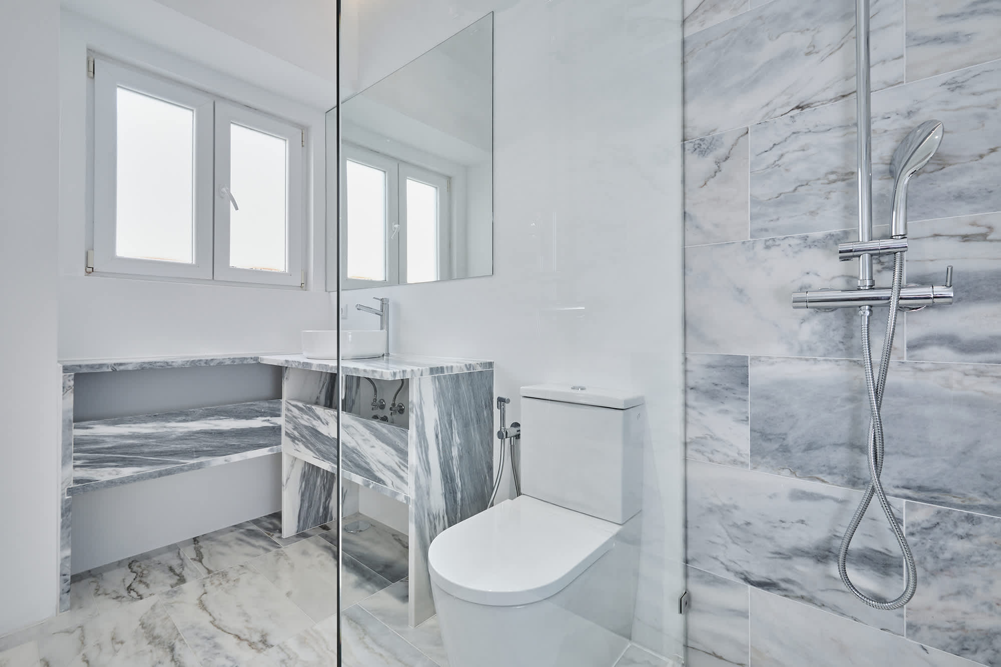 14-Apartamento-Lisboa-Lisboa - O apartamento insere-se num edifício de gaveto entre a Avenida de Berna e Avenida Marquês de Tomar no bairro das Avenidas Novas, localizado na zona central de Lisboa, junto à Avenida da República, uma das principais vias da cidade. A Avenida de Berna tem uma longa história de Glamour e estilo de vida de classe alta e essa cultura esteve presente na nossa forma de abordar o Projeto.
O bairro é definido por vias largas de dois sentidos, logradouros ajardinados e coerência estética no desenho das fachadas, tornando Avenida de Berna numa das zonas mais valorizadas de Lisboa. O edifício  é composto por um piso térreo e quatro pisos seguintes. A construção é definida por fundações em alvenaria de pedra, que é o mesmo material presente nas paredes exteriores. Os interiores por si, encontram-se em tijolo maciço, com uma laje mista e cobertura em telha marselha assente em barrotes de madeira. São criadas novas aberturas interiores, o layout da cozinha é alterado para permitir a continuidade e fluidez espacial entre o espaço social definido pelas divisões conectadas.
O alçado principal é definido por uma métrica de vãos com de guardas metálicas, assim como vãos exteriores em alumínio com vidro duplo e com uma cobertura de duas águas em cerâmica. Com a intervenção da CVZ Construções, nasce uma nova zona social. Uma nova disposição, com maior espacialidade e luminosidade, na cozinha, sala e Instalações Sanitárias. O novo espaço traz mobiliário fixo de biblioteca e zonas de iluminação indireta.