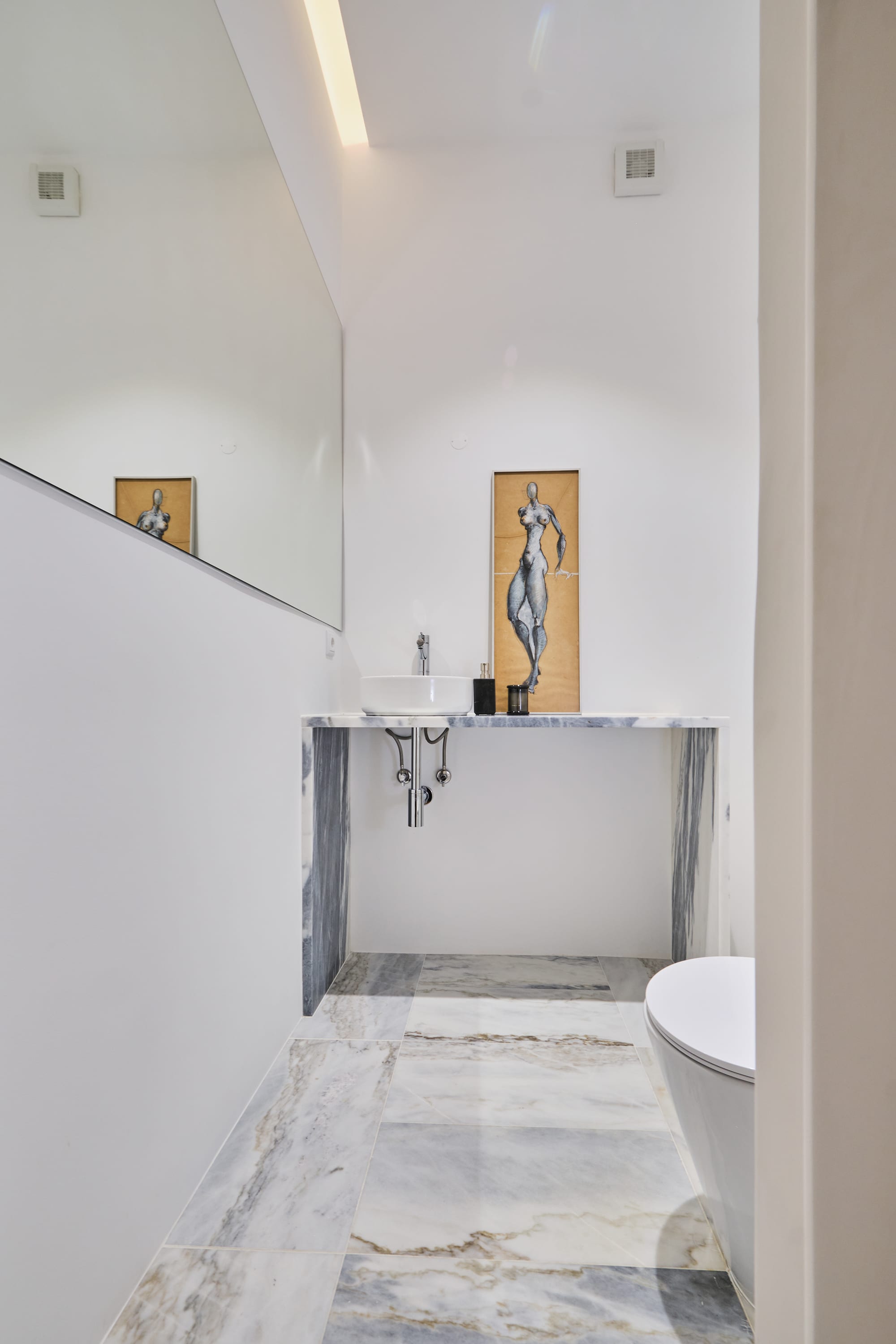 16-Apartamento-Lisboa-Lisboa - O apartamento insere-se num edifício de gaveto entre a Avenida de Berna e Avenida Marquês de Tomar no bairro das Avenidas Novas, localizado na zona central de Lisboa, junto à Avenida da República, uma das principais vias da cidade. A Avenida de Berna tem uma longa história de Glamour e estilo de vida de classe alta e essa cultura esteve presente na nossa forma de abordar o Projeto.
O bairro é definido por vias largas de dois sentidos, logradouros ajardinados e coerência estética no desenho das fachadas, tornando Avenida de Berna numa das zonas mais valorizadas de Lisboa. O edifício  é composto por um piso térreo e quatro pisos seguintes. A construção é definida por fundações em alvenaria de pedra, que é o mesmo material presente nas paredes exteriores. Os interiores por si, encontram-se em tijolo maciço, com uma laje mista e cobertura em telha marselha assente em barrotes de madeira. São criadas novas aberturas interiores, o layout da cozinha é alterado para permitir a continuidade e fluidez espacial entre o espaço social definido pelas divisões conectadas.
O alçado principal é definido por uma métrica de vãos com de guardas metálicas, assim como vãos exteriores em alumínio com vidro duplo e com uma cobertura de duas águas em cerâmica. Com a intervenção da CVZ Construções, nasce uma nova zona social. Uma nova disposição, com maior espacialidade e luminosidade, na cozinha, sala e Instalações Sanitárias. O novo espaço traz mobiliário fixo de biblioteca e zonas de iluminação indireta.