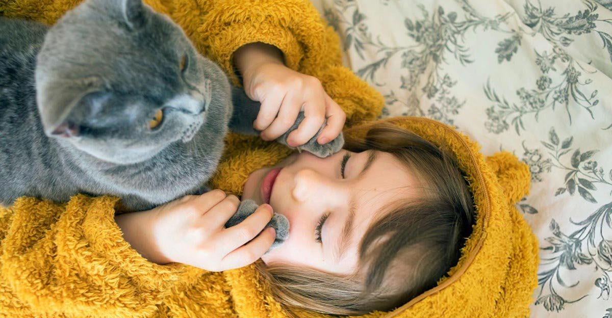 Enfant tenant délicatement un chaton, illustrant l’entente entre chaton et enfants.