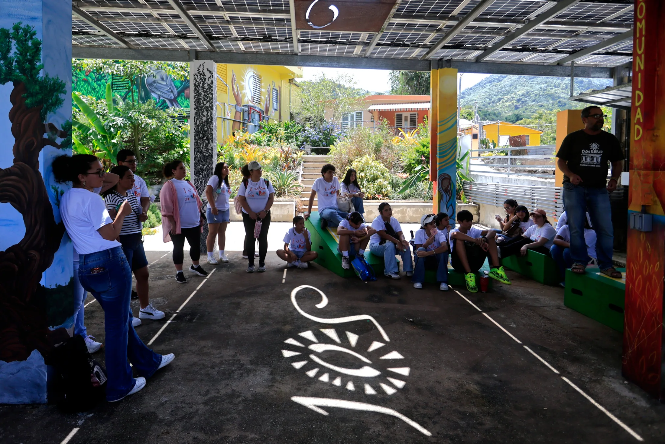 Adjuntas, Puerto Rico, 06/24/2026. The sun shines through an installation by artist Antonio Martorell, as Arturo Massol Deyá, director of the organization Casa Pueblo, shows students from the University of Puerto Rico how solar microgrids function and how they connect to one another through the Microgrid Orchestrator | Thais Llorca for The Parlor Magazine