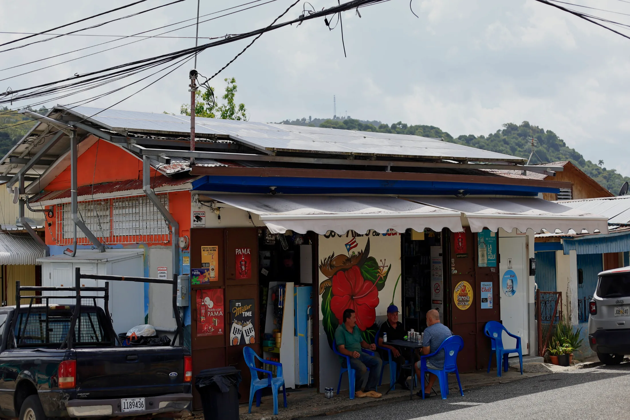 Adjuntas, Puerto Rico, 06/24/2026. Customers at the grocery store of Sharon Cedeño, owner of Colmado Alto de Cuba, part of the town's solar community. | Thais Llorca for The Parlor Magazine