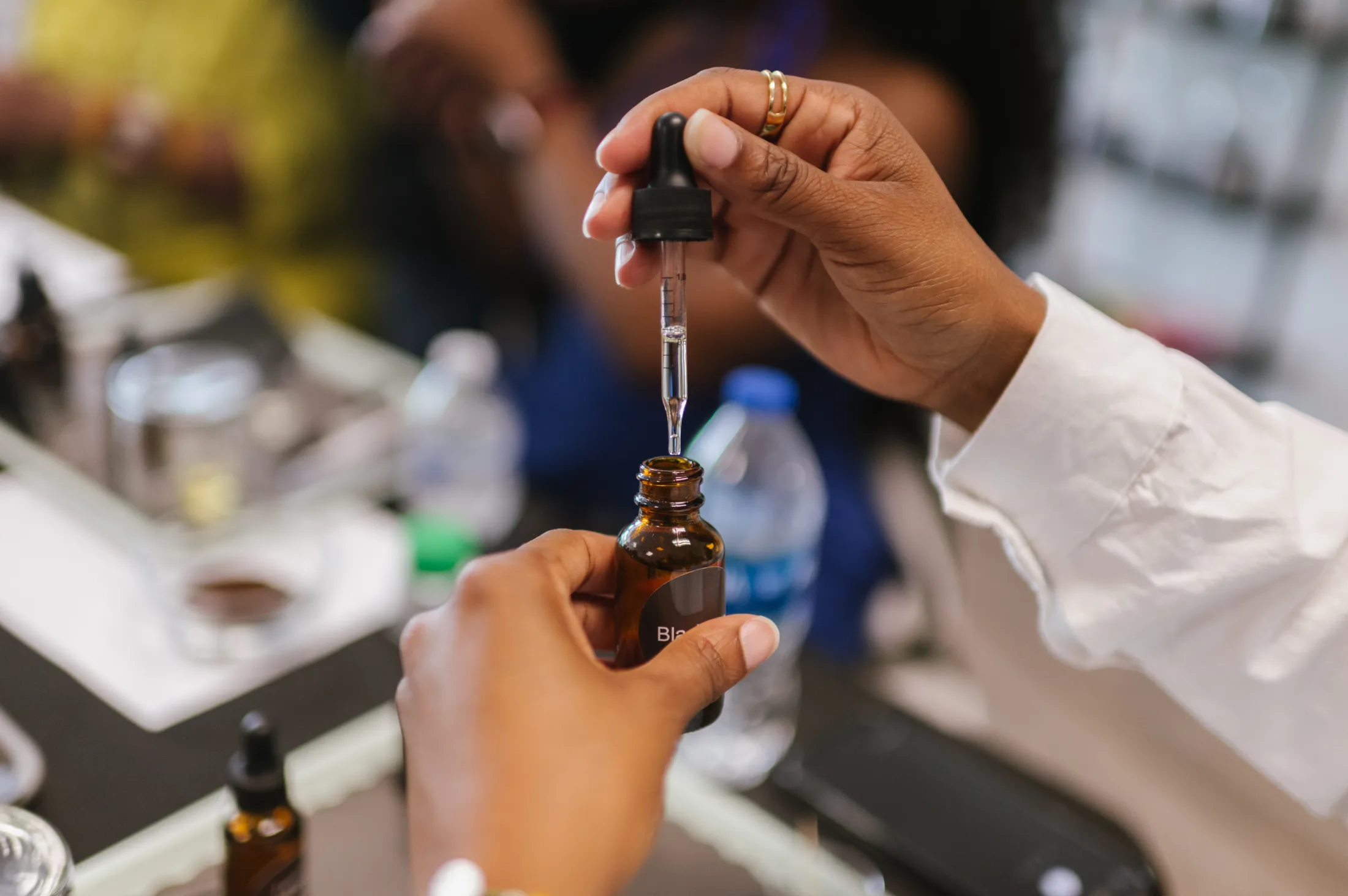 A participant uses a dropper to blend fragrances during a scent-making workshop at Bright Black in Durham, North Carolina. The hands-on experience invites participants to explore scent as a form of creativity, self-expression, and personal storytelling. Used with permission.