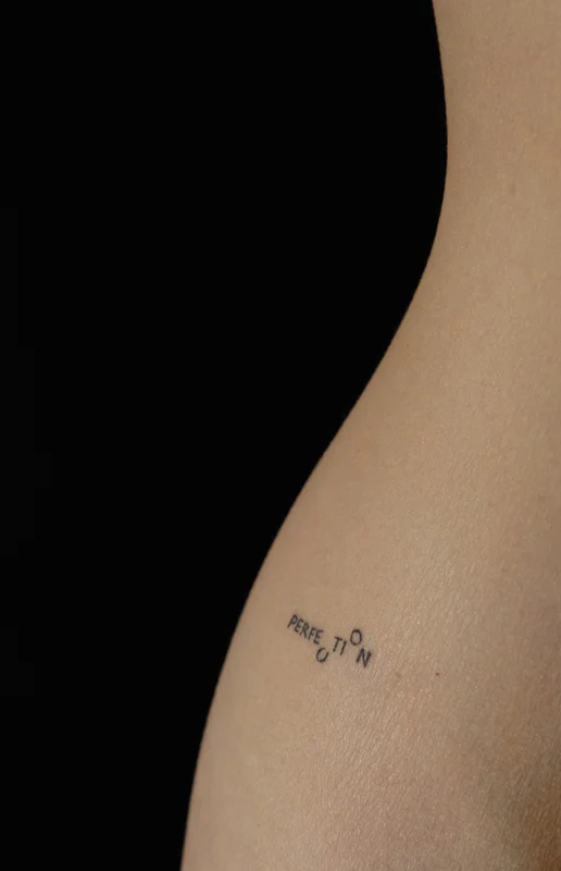 Tattoo inscription on the thigh Perfection