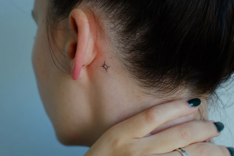 Star tattoo behind the ear