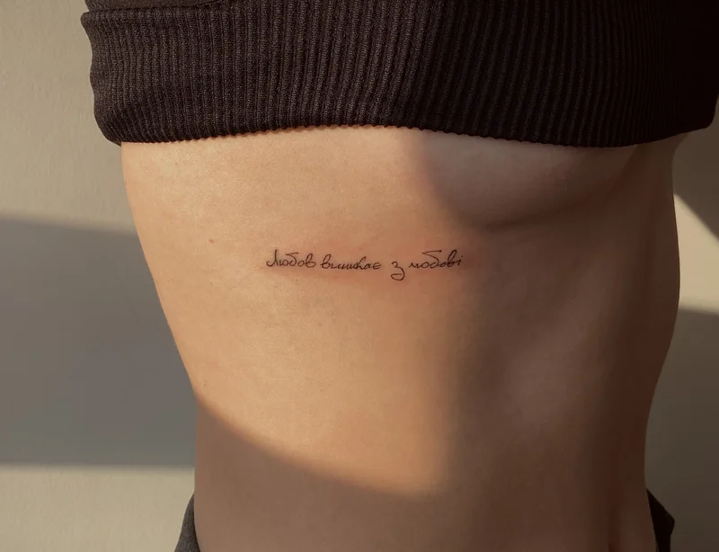 Inscription tattoo on the ribs in Ukrainian