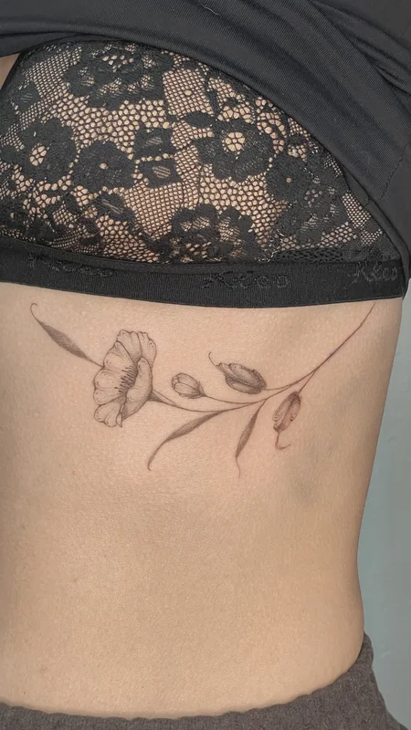 Cherry blossom branch tattoo on ribs