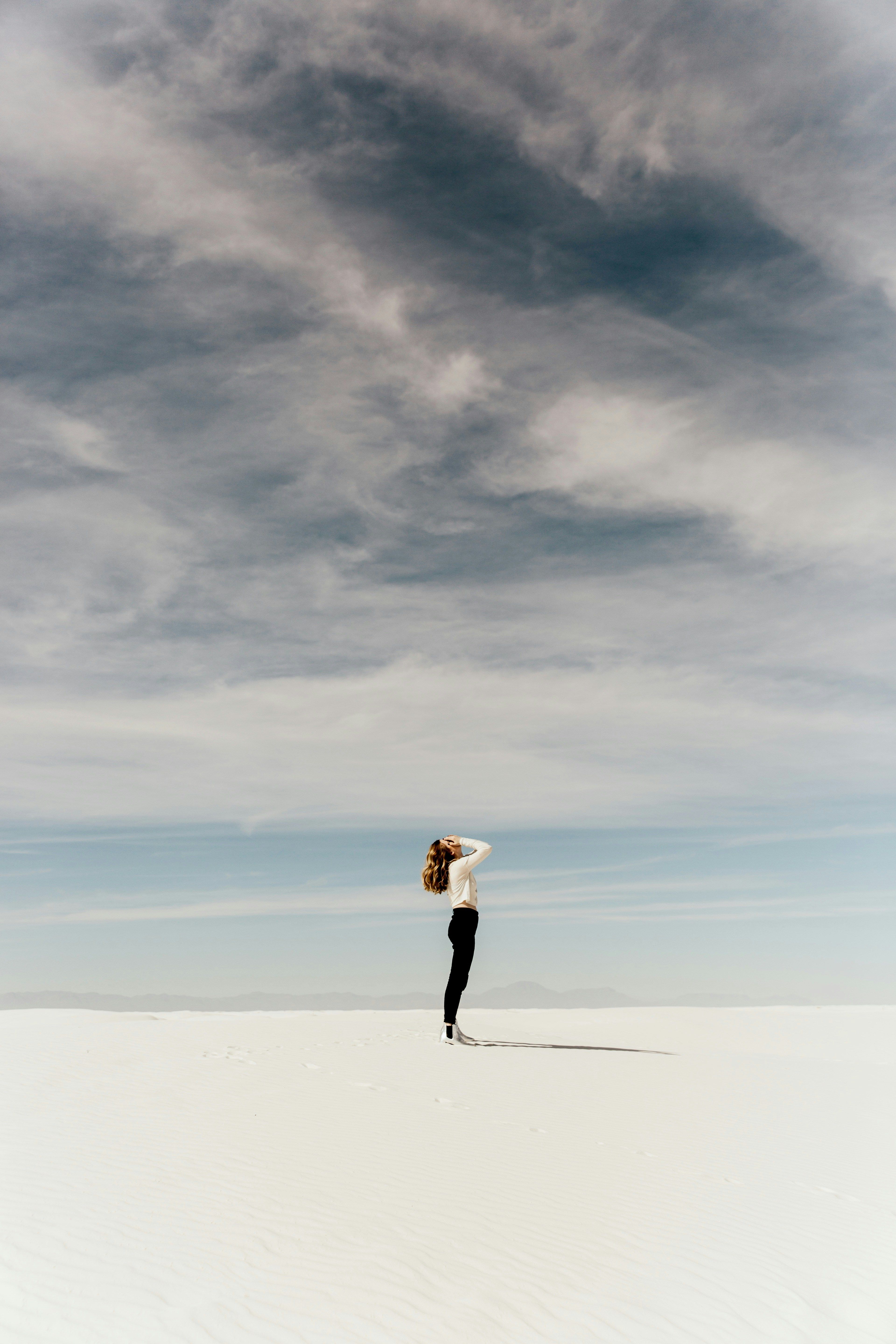 A women at the beach under grey clouds
