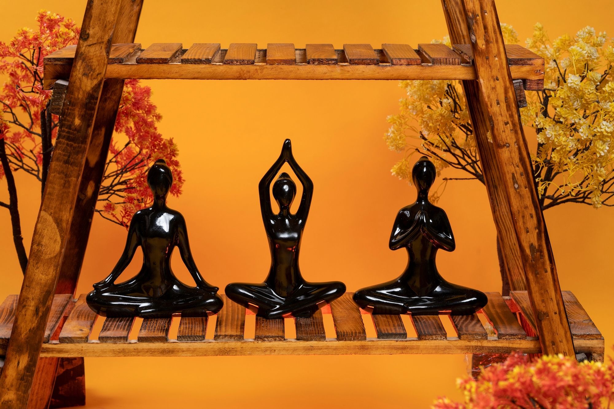 Three figures doing simple sitting yoga poses