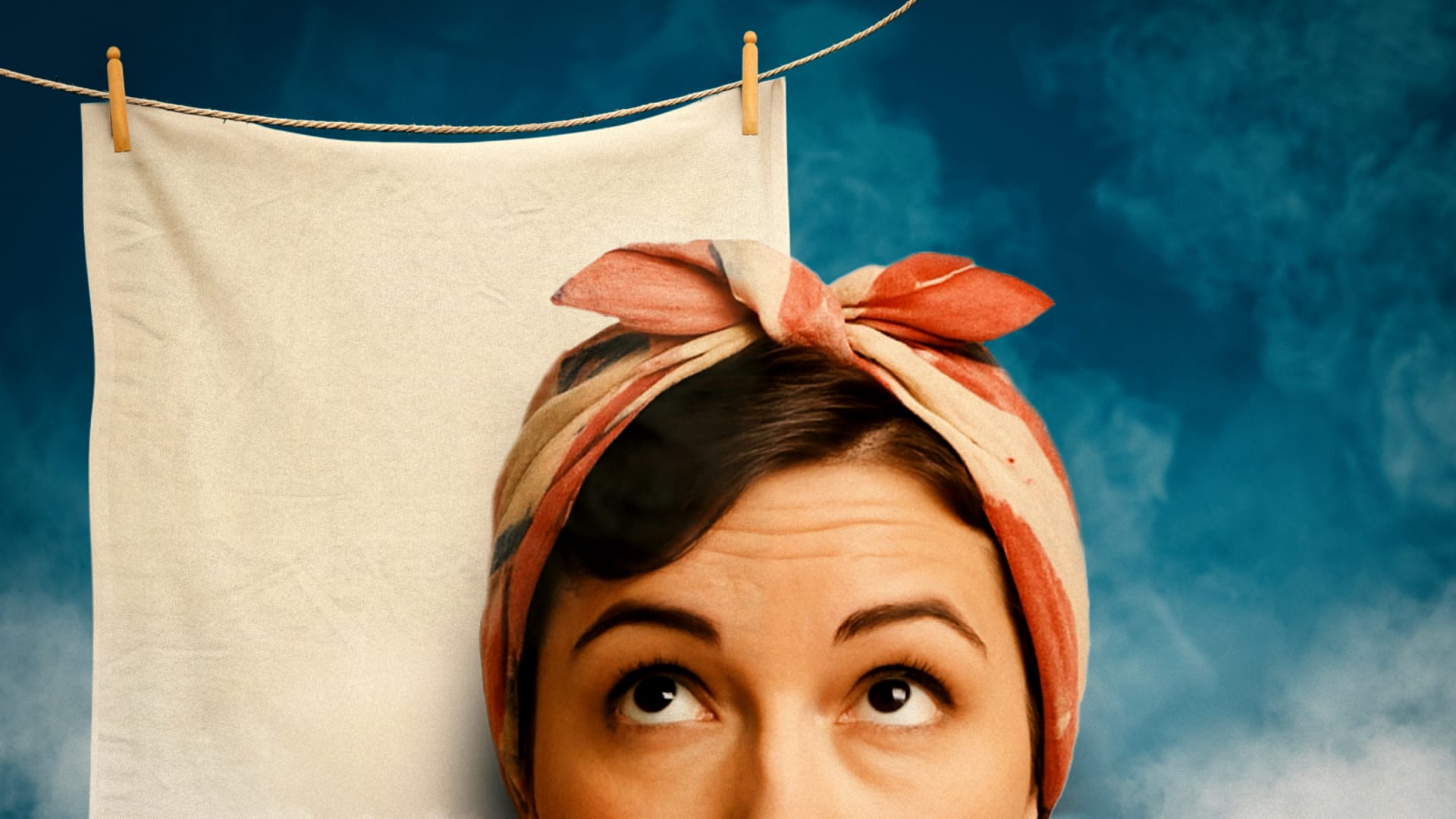 Person wearing a knotted rust-and-beige headscarf peering upward in front of a cream linen cloth pegged to a washing line against a teal background.