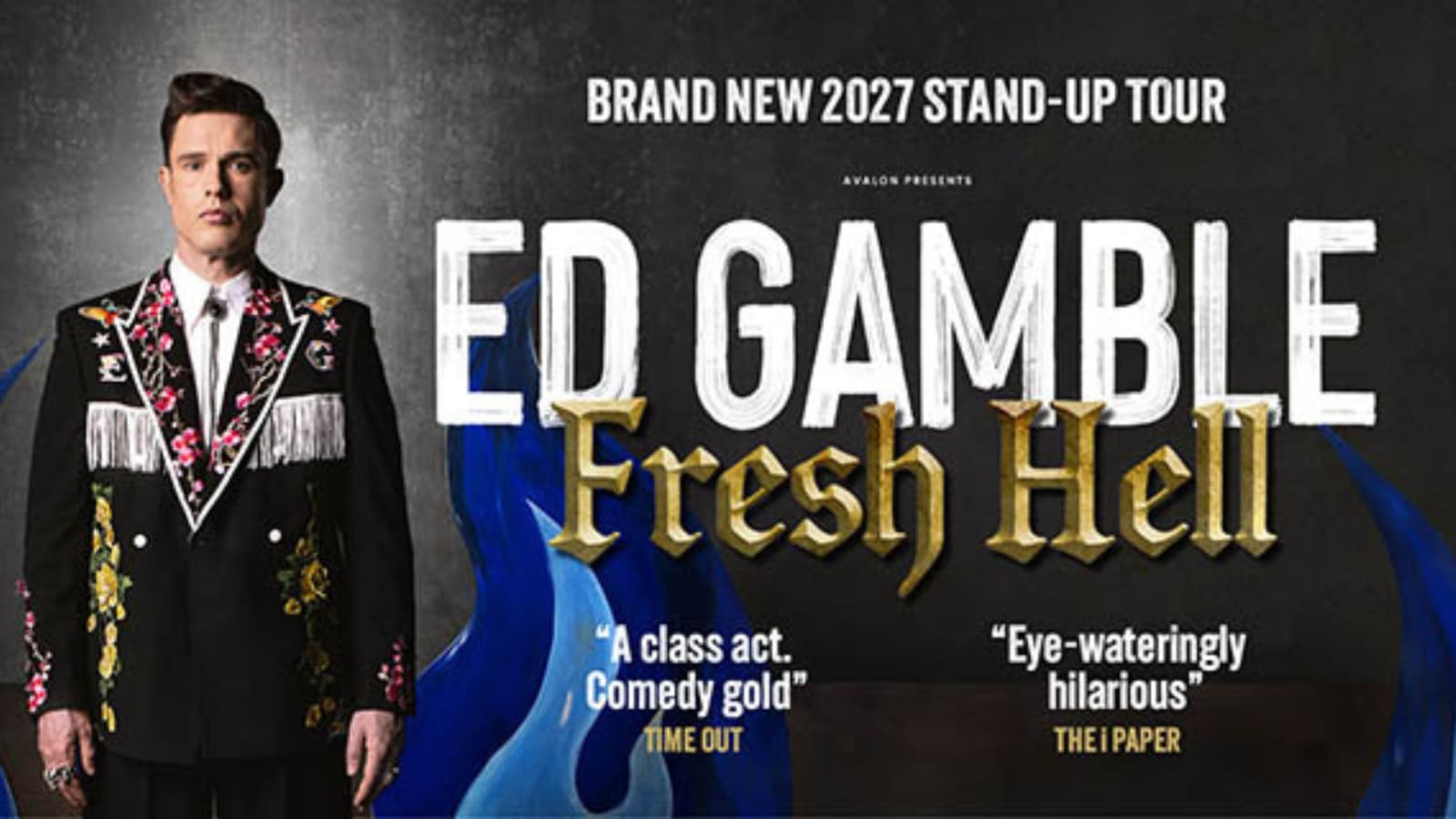 Tour poster reading 'Brand New 2027 Stand-Up Tour – Avalon Presents Ed Gamble: Fresh Hell', with the performer in a floral fringed black jacket beside painted blue flame props on a dark background.