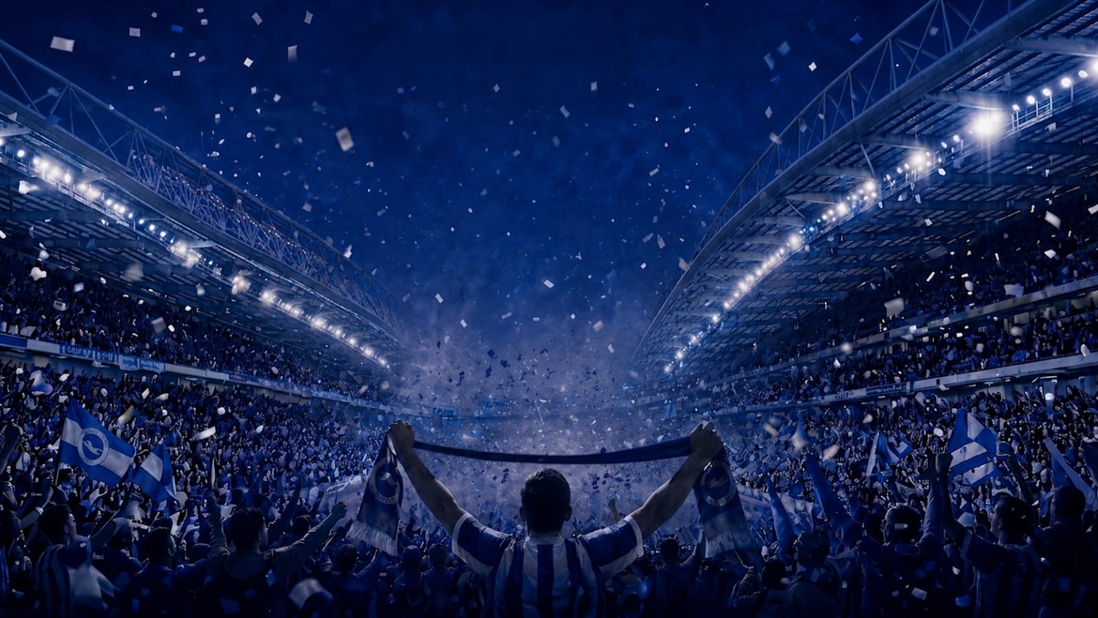 A floodlit football stadium packed with supporters, with a figure in a blue and white striped shirt holding a scarf aloft in the foreground.