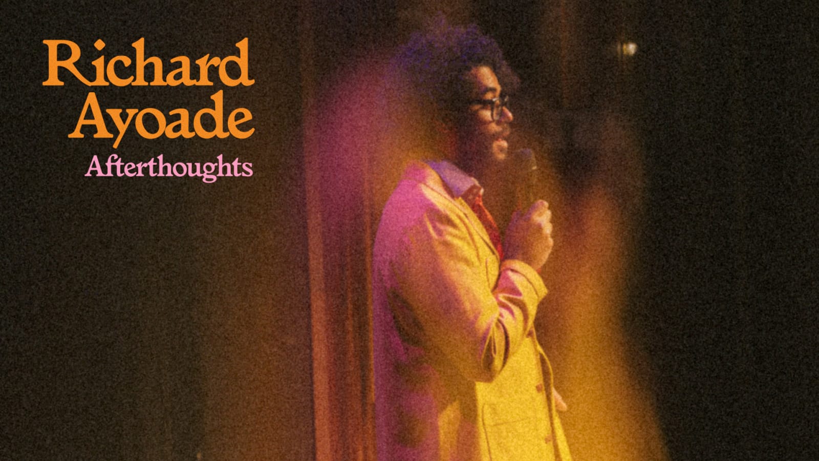 Promotional image with the title 'Richard Ayoade - Afterthoughts' in orange and pink text over a grainy photograph of a person in a yellow jacket holding a microphone under amber and pink stage lighting