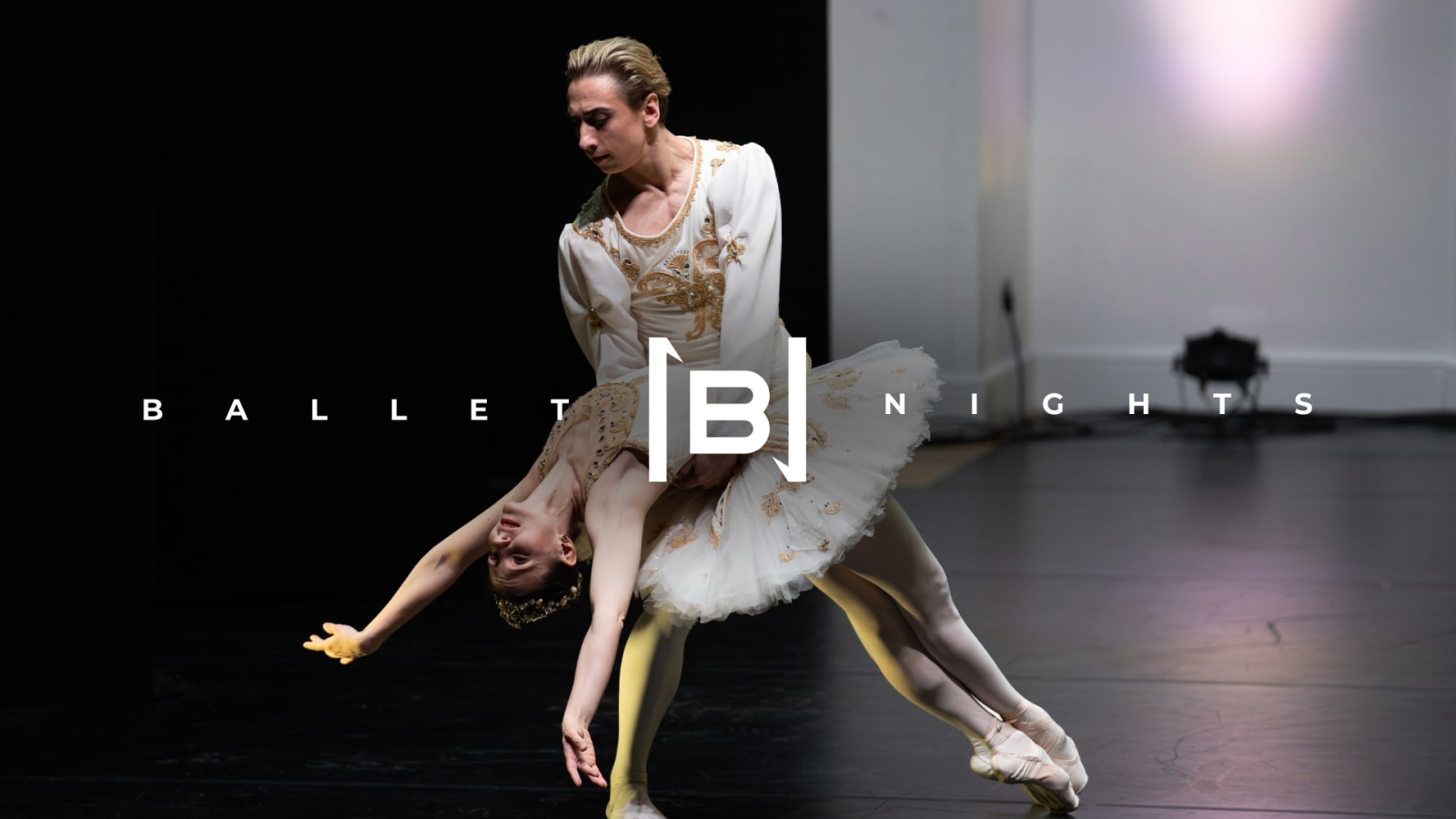 Ballet Nights title text with a stylised B logo overlaid on a stage photograph of two dancers in white and gold costumes.