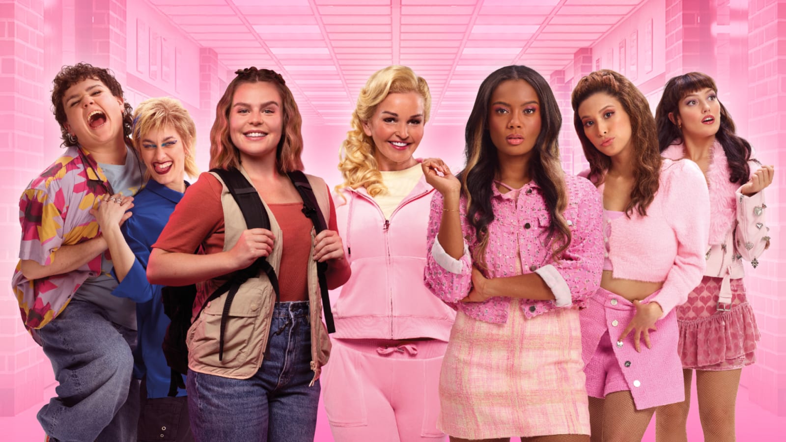 Seven performers posed against a bright pink school corridor backdrop in colourful and coordinated pink outfits.