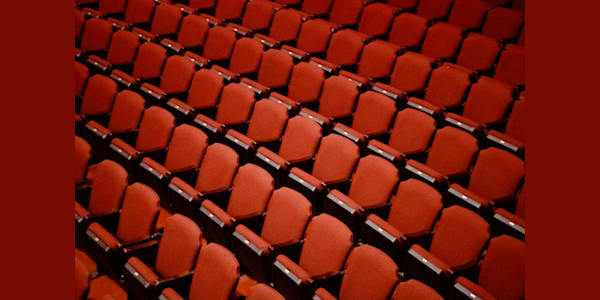 Empty red stadium-style or movie-theatre style seats at the Kings Theatre.