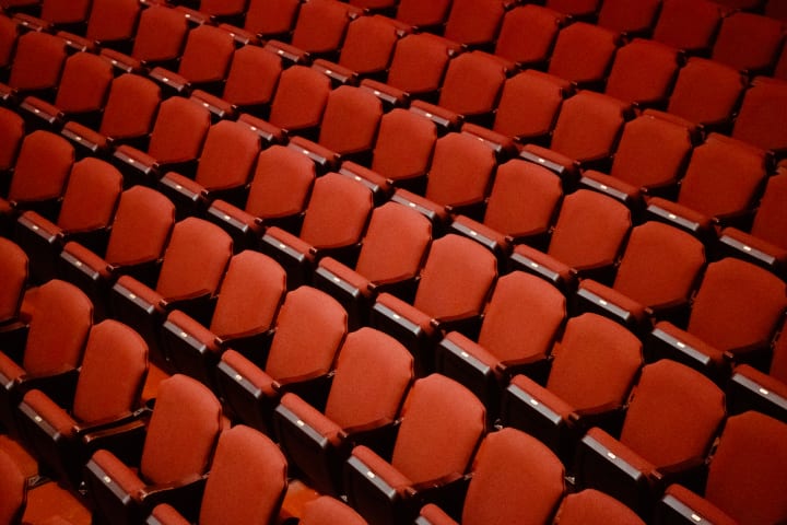 Empty red stadium-style or movie-theatre style seats at the Kings Theatre.