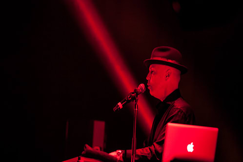 Man on stage singing in red light