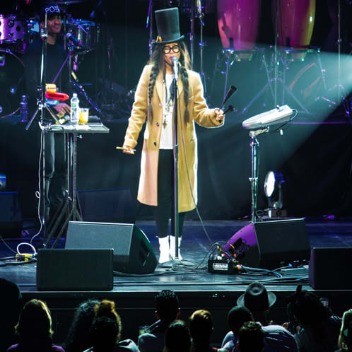 person on stage in yellow coat and black top hat