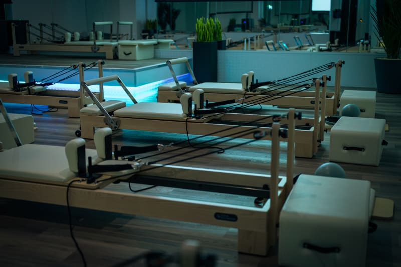 Reformer Pilates machines lined up in the Reformer studio.